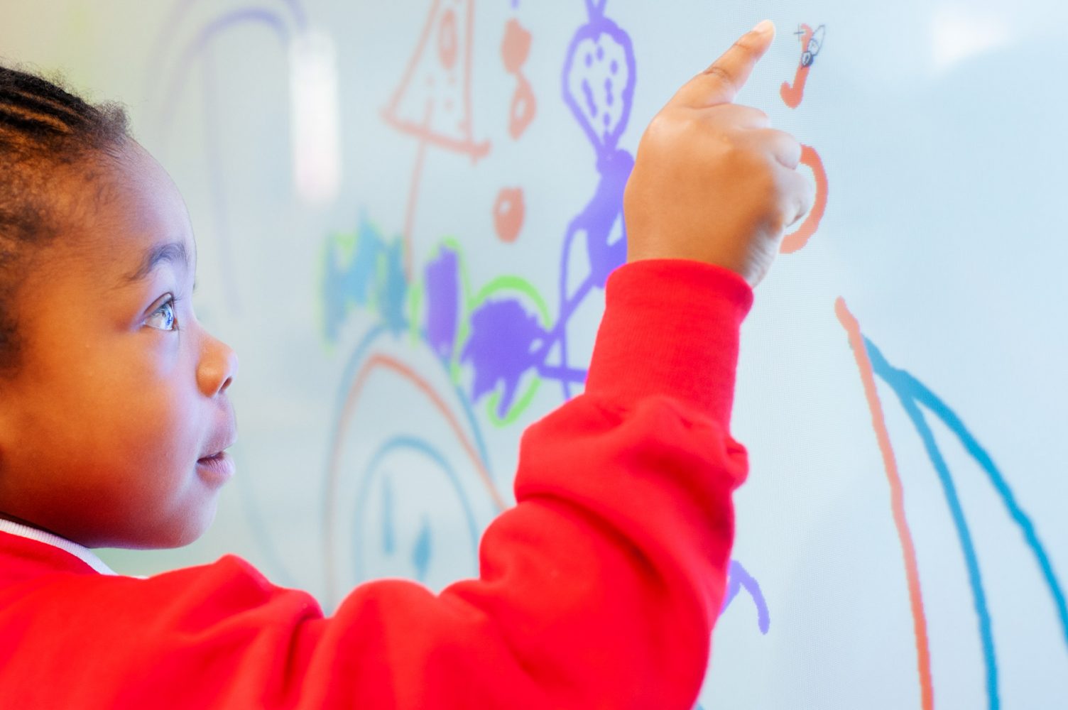 School pupil using touch screen whiteboard