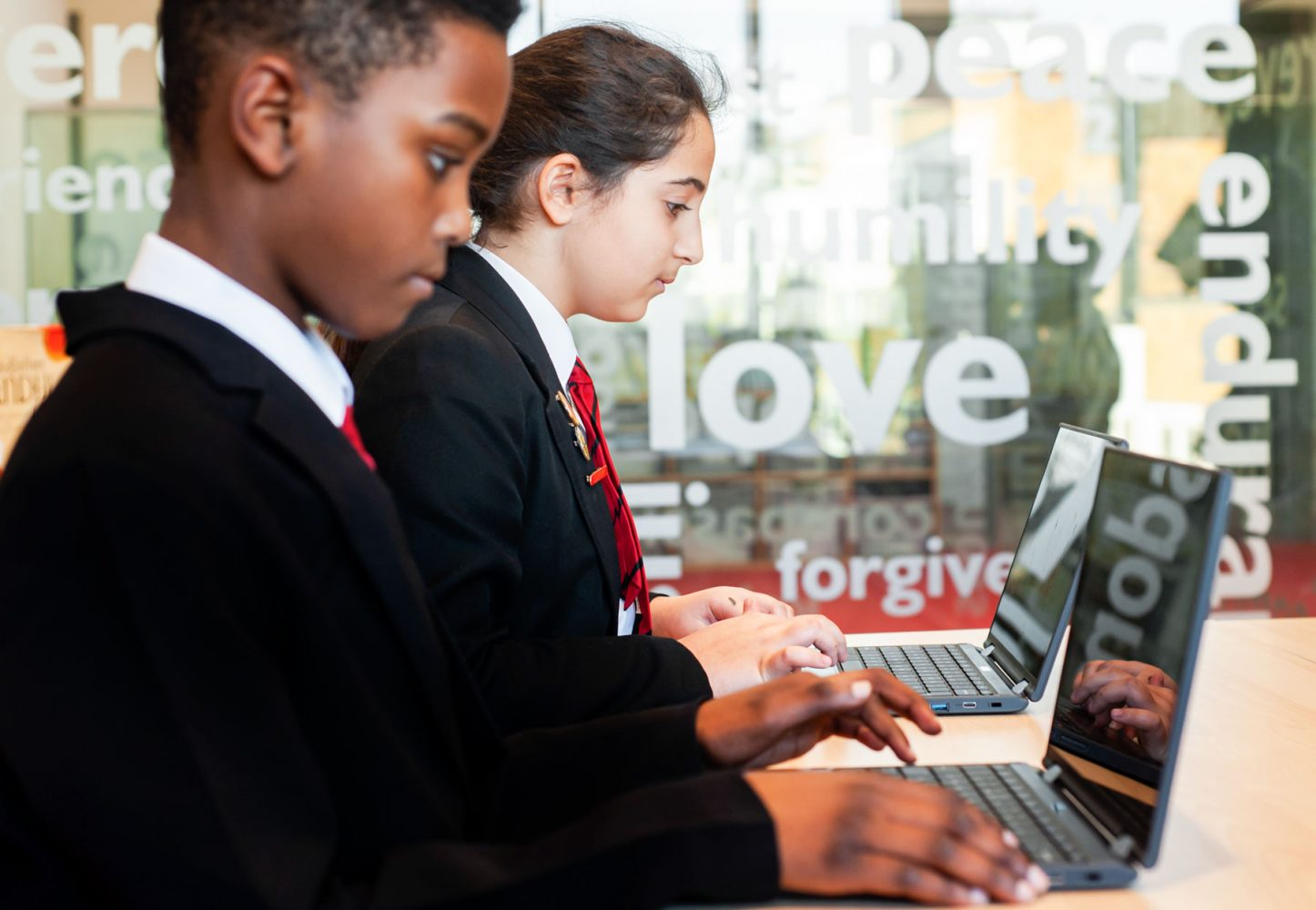 Pupils typing on laptops