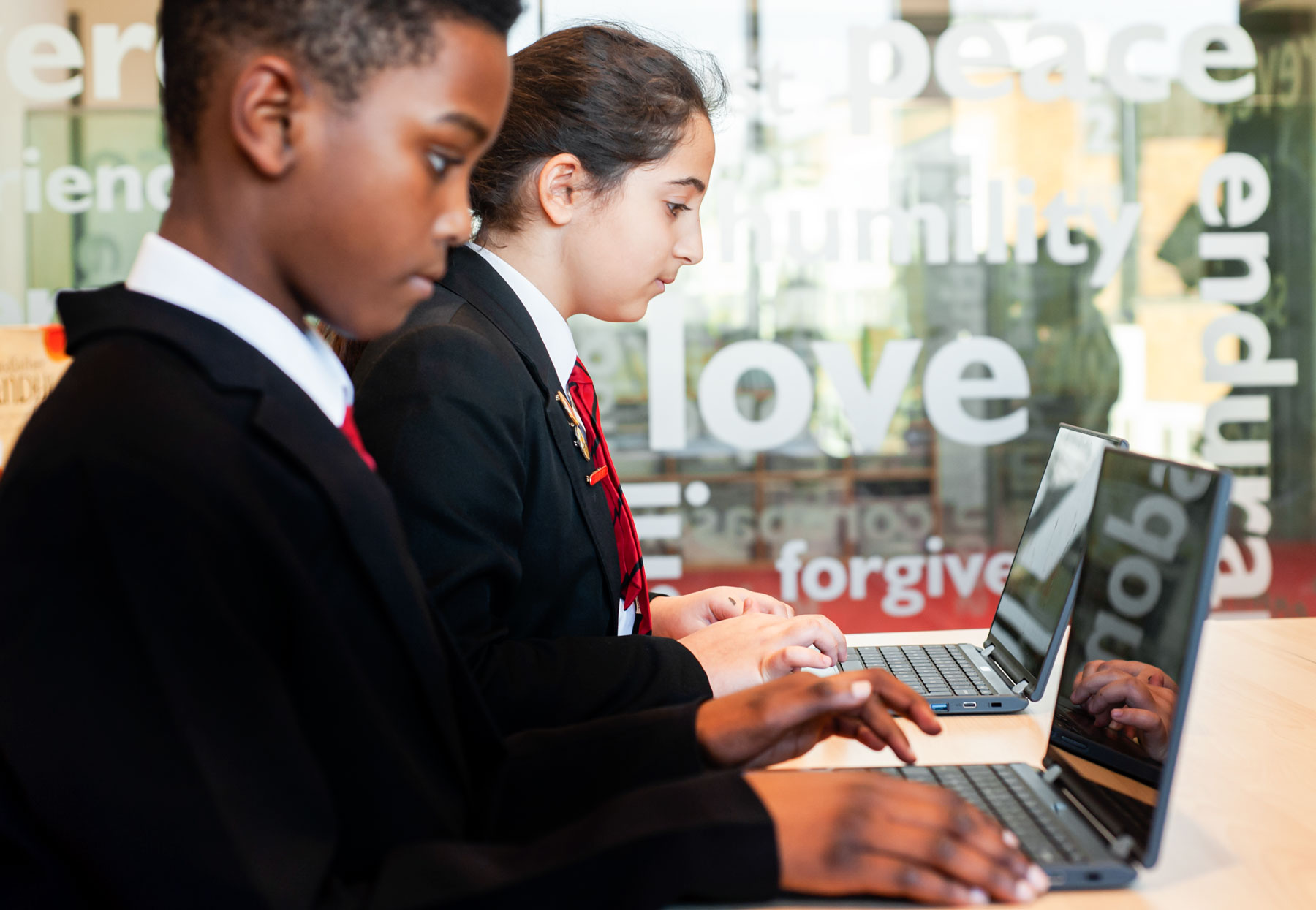 Pupils typing on laptops